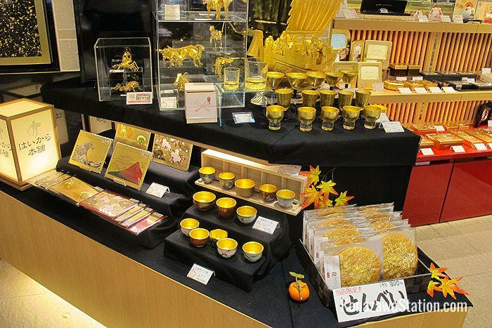 Gold leaf goods on display include ornaments, lacquerware with gold leaf inlay, and even (on the lower right) big round rice crackers decorated with flecks of gold!