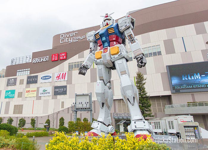A statue of Gundam, the iconic robot from the anime franchise Mobile Suit Gundam towers over visitors in Odaiba