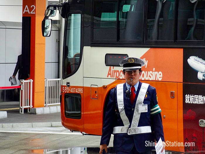 A bus parking agent sees off an airport shuttle at Basuta Shinjuku