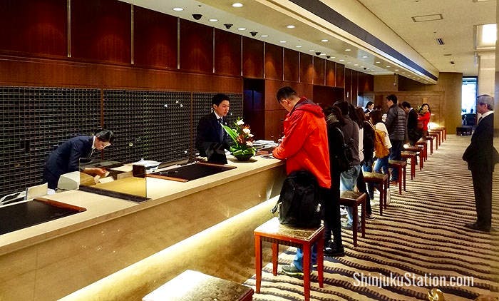 The lobby’s front desk bustles with uniformed staff