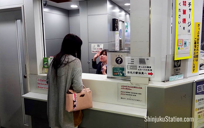 Staff at a booth by the South Exit ticket gates help direct passengers