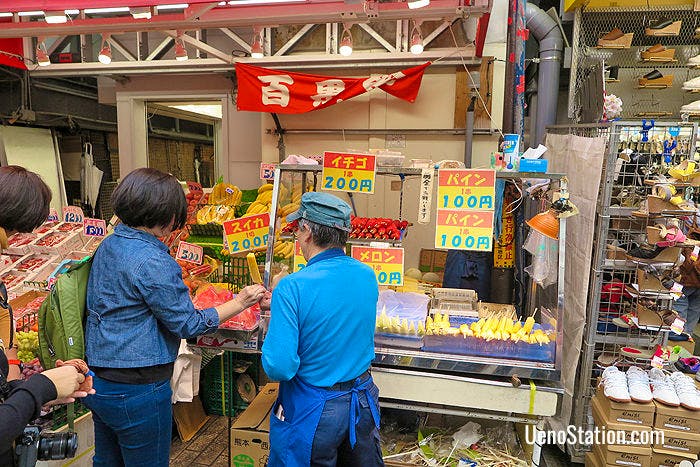 Buying a pineapple slice at Hyakkaen New Fruit
